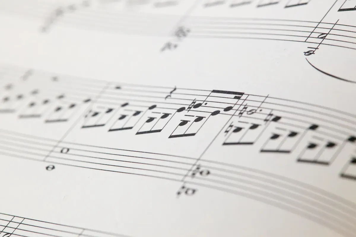 Detailed view of printed musical notes on a white sheet of paper.